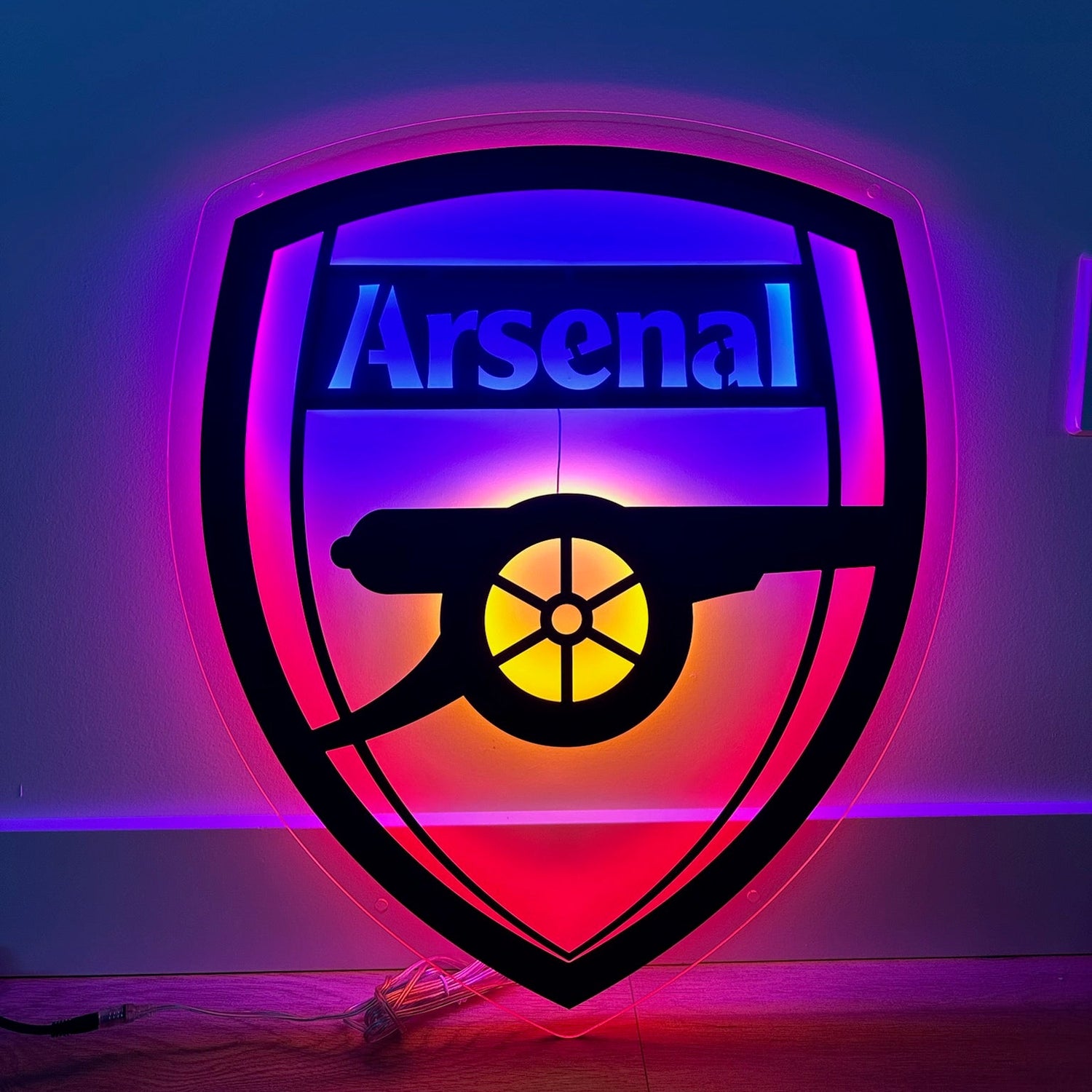 Neon sign of Arsenal logo on a dark background