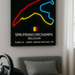 Neon sign map of Spa-Francorchamps race track on a wall above a bed.