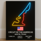 Neon sign of a race track with Circuit of the Americas branding on a black background.