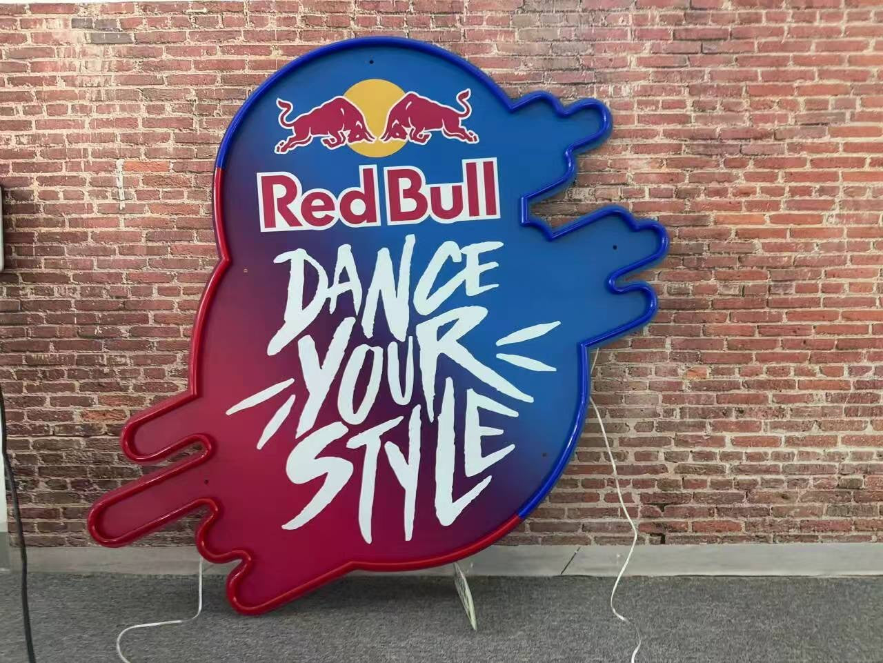 Red Bull sign with 'Dance Your Style' text against a brick wall