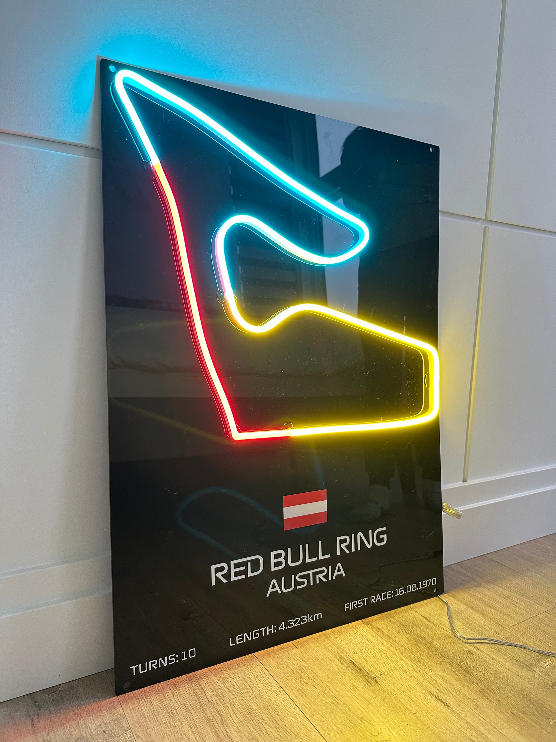 Neon light display of a race track layout with 'Red Bull Ring Austria' branding.