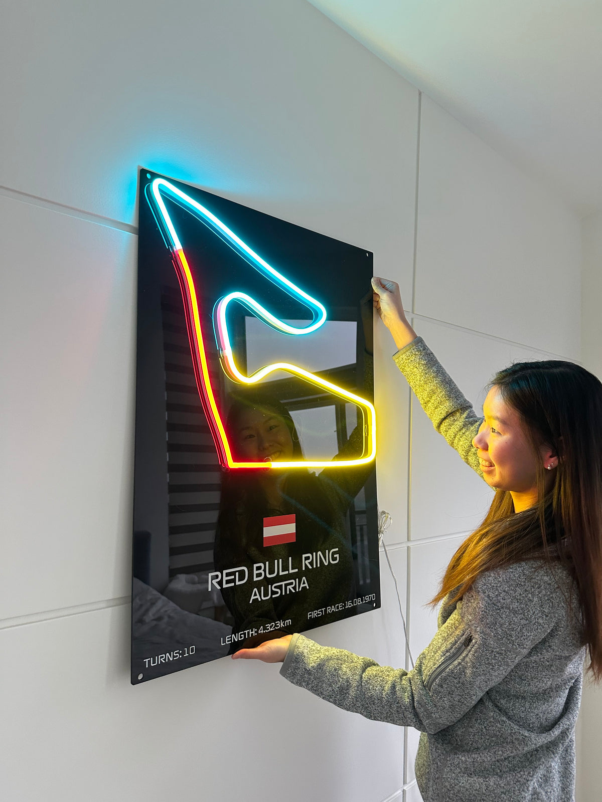 Person interacting with a neon sign on a tiled floor