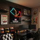 Gaming room setup with racing-themed decor, including neon sign and race car posters.