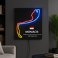Neon sign of a race track with Monaco details on a dark wall.