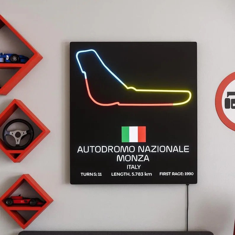 Neon sign of a race track layout with Italian flag and race details on a black background, mounted on a wall.