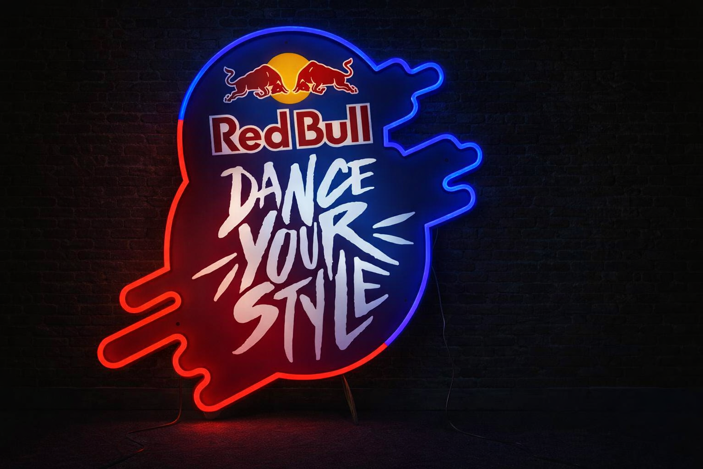 Custom neon sign with Red Bull logo and 'Dance Your Style' text on a dark background