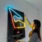 Person interacting with a neon sign of Red Bull Ring Austria on a white wall.