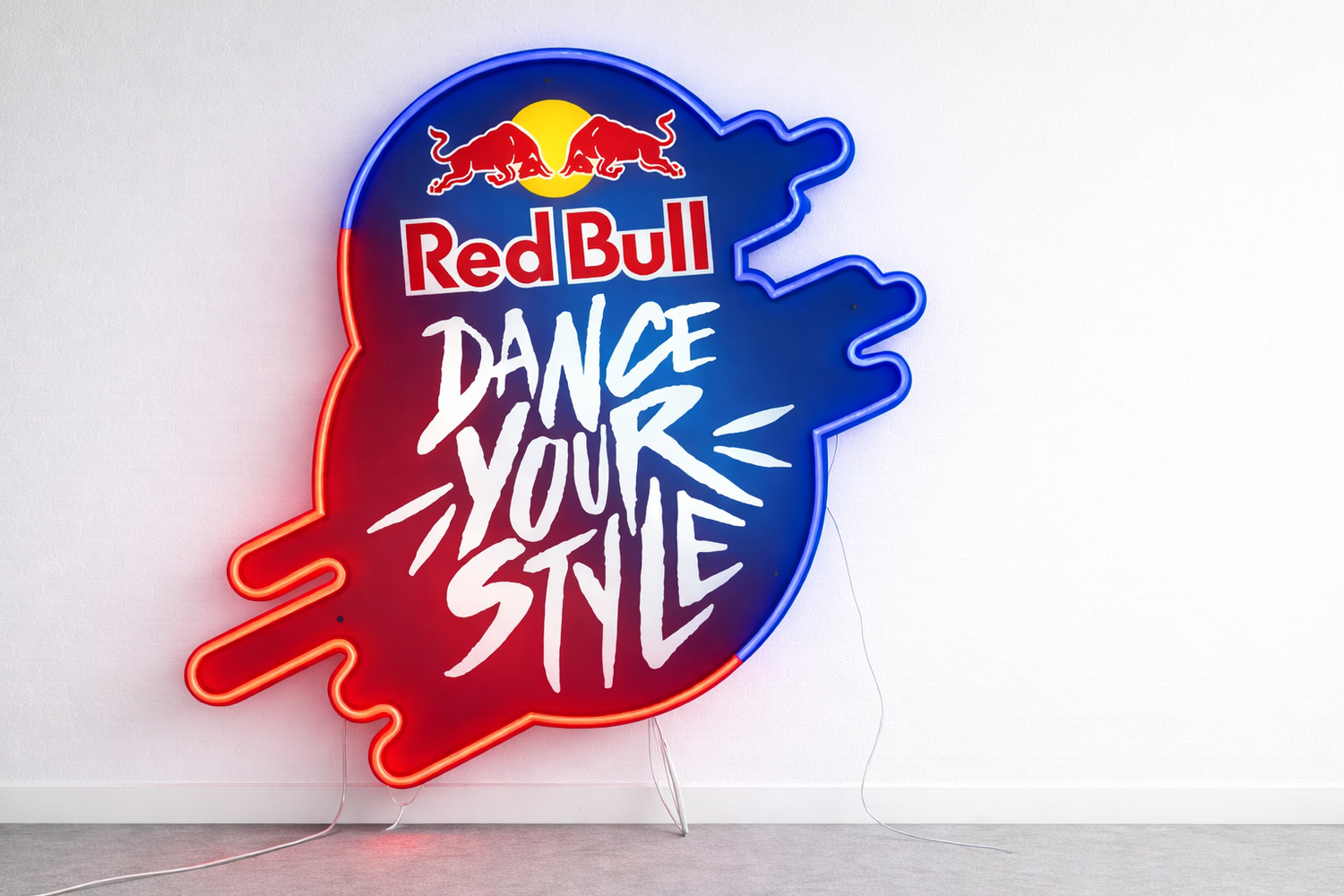 Neon sign with Red Bull logo and 'Dance Your Style' text on a white background
