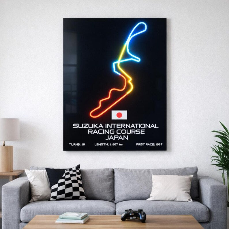 Neon wall art of Suzuka International Racing Course on a white wall above a gray sofa.