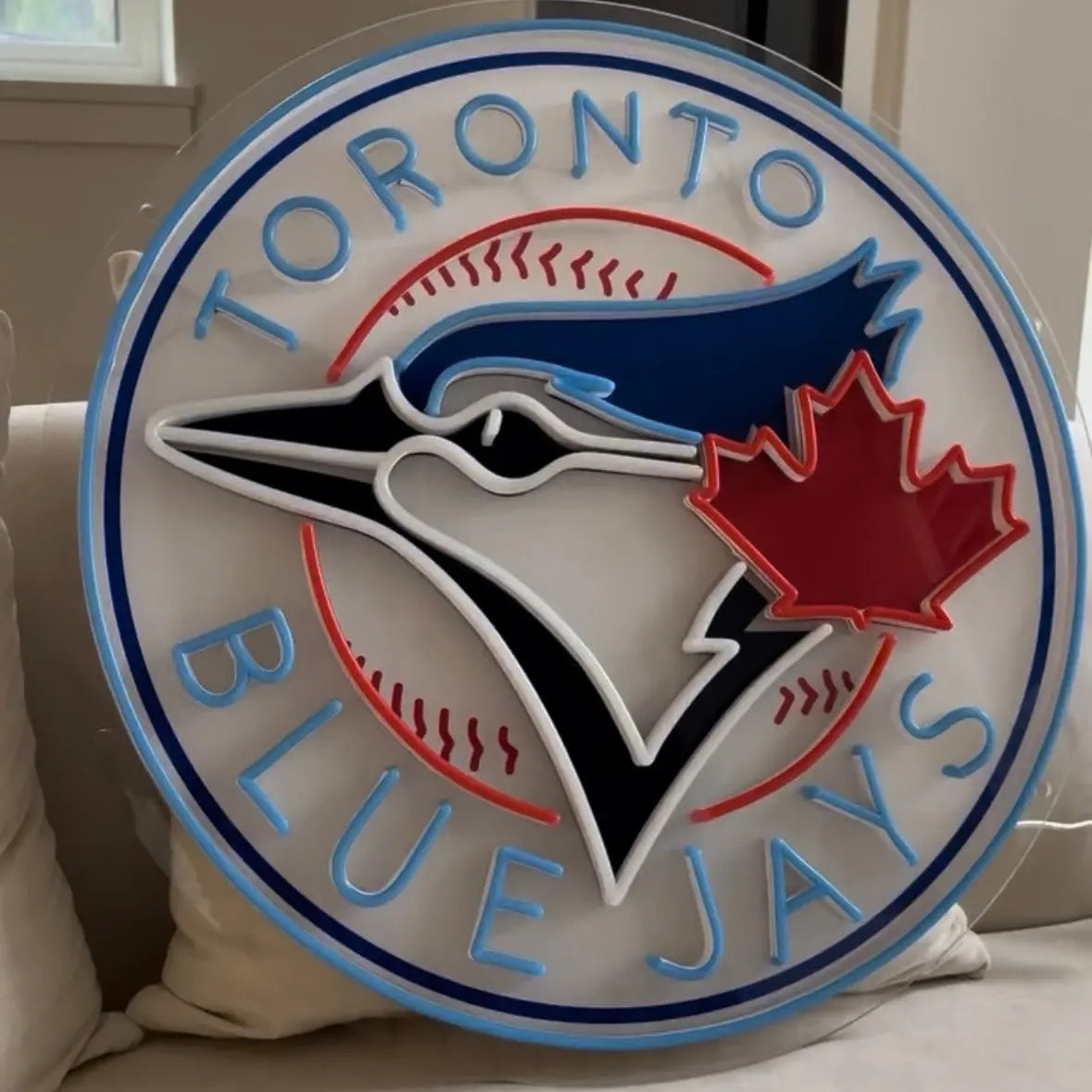 Toronto Blue Jays logo neon sign on a decorative wall piece in a room.