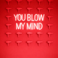 Neon sign with 'YOU BLOW MY MIND' text on a red wall with decorative elements.