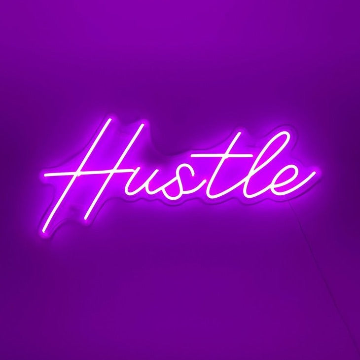 Hustle neon sign in bedroom above bed